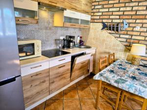 a kitchen with a sink and a microwave and a table at Domki Gama-Spa in Władysławowo +61 photos