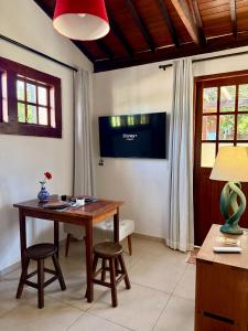 a living room with a wooden table and chairs at Mini Casa-Aconchego e Fitness in Pirenópolis