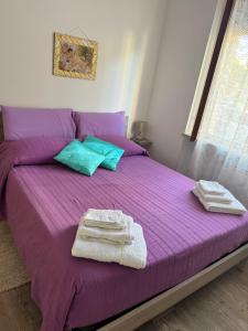 a purple bed with towels on top of it at La casetta di Nino in Termoli