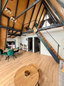 an attic living room with a wooden ceiling and a table at Nature View Breaza in Breaza de Sus