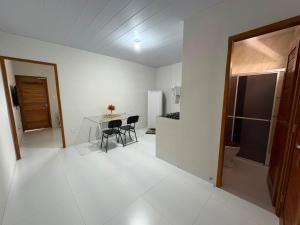 a kitchen and dining room with a table and chairs at Kitnet Vista do Vale in Areia