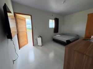 a small room with a bed and a window at Kitnet Vista do Vale in Areia