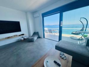 a living room with a view of the ocean at NV seafront Villa with private pool & NV seafront luxury suites no pool acces - Aegina in Áyioi +79 photos