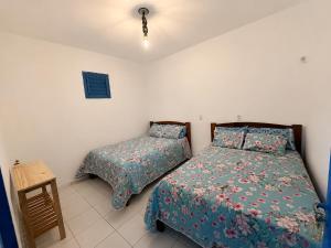 a bedroom with two beds and a night stand at Pousada Flor de Sal in Prea