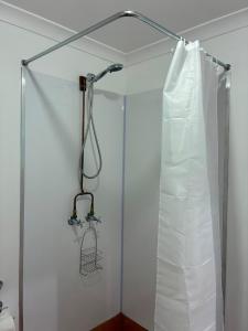 a shower in a bathroom with a shower curtain at Yurts at Yelverton in Yelverton +10 photos