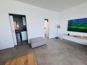 a living room with a large tv on the wall at NV seafront Villa with private pool & NV seafront luxury suites no pool acces - Aegina in Áyioi