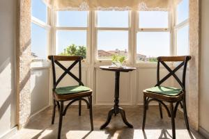 two chairs and a table in front of a window at Alacati Kostem Hotel - Special Category in Alaçatı