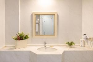 a white bathroom with a sink and a mirror at Alacati Kostem Hotel - Special Category in Alaçatı +52 photos