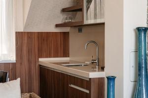 a kitchen with a sink and wooden cabinets at Tihany Panoráma Apartman in Tihany +10 photos