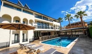 a hotel with a swimming pool and a building at Jest Hotel in Kemer