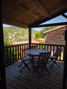 a picnic table and two chairs on a deck at Chalet a louer avec piscine in Solliès-Toucas