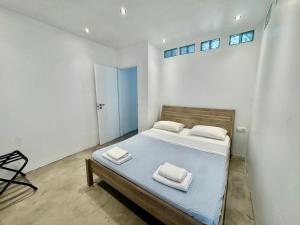 a bedroom with a bed with two towels on it at NV seafront Villa with private pool & NV seafront luxury suites no pool acces - Aegina in Áyioi