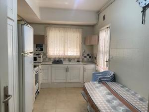 a small kitchen with a sink and a refrigerator at Confort house-au bord de la mer in Nabeul