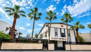 a building with palm trees in front of it at Jest Hotel in Kemer