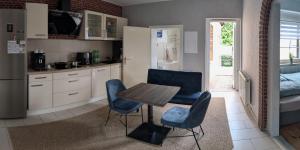 a kitchen with a table and two blue chairs at Chez D&D Plus in Eschweiler +13 photos