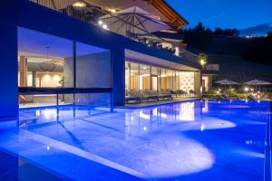 una grande piscina in una casa di notte di Hotel Christoph a Valdaora