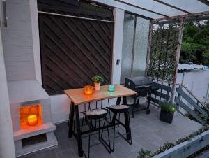 a patio with a wooden table and chairs and a grill at Chez D&D Plus in Eschweiler