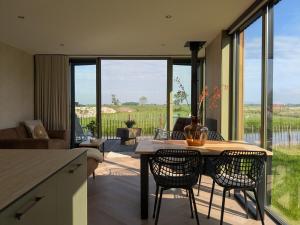 a kitchen and living room with a table and chairs at B&B Het Houten Huis in Brandwijk