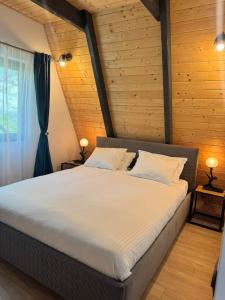 a large bed in a room with a wooden wall at Nature View Breaza in Breaza de Sus
