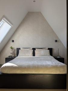 a bedroom with a large bed in a attic at B&B Het Houten Huis in Brandwijk