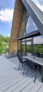 a wooden deck with a table and chairs on a building at Nature View Breaza in Breaza de Sus