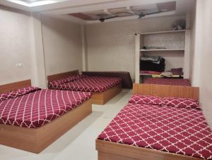 two beds in a room with red comforter at Nandan Palace in Godarpura