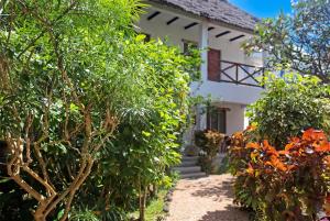a white house with trees in front of it at Villa Kiota in Paje