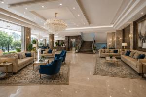a living room with couches and a chandelier at Hotel The Prithvi Delhi Airport With Free Airport Pic Up in New Delhi