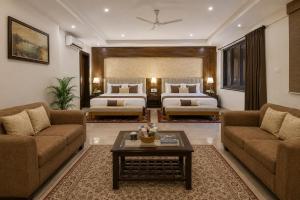 a living room with two beds and a couch and a table at Hotel The Prithvi Delhi Airport With Free Airport Pic Up in New Delhi +82 photos