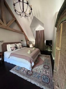 a bedroom with a large bed and a chandelier at Orpheus Lodge in Giverny