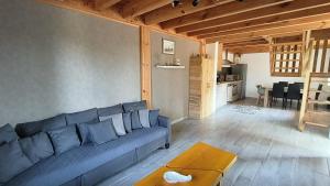 a living room with a blue couch and a table at La maison d'Irma in Lanton