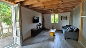 a living room with a couch and a table at La maison d'Irma in Lanton