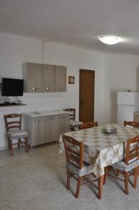 a room with a table and chairs and a kitchen at Nonna Rosa's Apartment in Pisticci