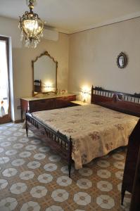 a bedroom with a large bed and a mirror at Nonna Rosa's Apartment in Pisticci