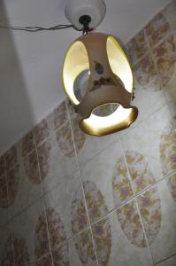 a gold mask hanging from a ceiling in a bathroom at Nonna Rosa's Apartment in Pisticci