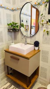 a bathroom with a sink and a mirror at Suíte privativa - Centro Guararema in Guararema