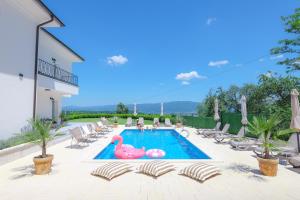 a swimming pool with two pink flamingos in a backyard at Vila sa bazenom Vrnjačka Idila in Vrnjačka Banja