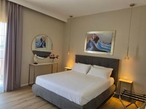 a bedroom with a white bed and two mirrors at Villa Merilusi Apartments in Fontane Bianche +79 photos