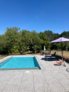 a swimming pool with an umbrella and a table and chairs at Domaine Bassy in Saint-Gengoux-de-Scissé