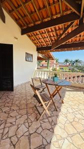 a table and chairs on a patio with a roof at Suíte privativa - Centro Guararema in Guararema