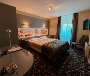 a hotel room with a bed and a desk at Hôtel de La Cloche in Dole