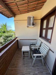 a balcony with two chairs and a heater at Bela Vista in Canoa Quebrada