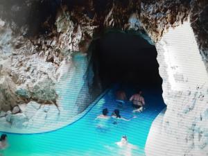 a group of people swimming in a blue pool in a cave at KASTELY ViLLA MISKOLCTAPOLCA in Miskolc