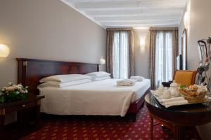 a hotel room with a large bed and a table at Albergo Cavalletto & Doge Orseolo in Venice +102 photos