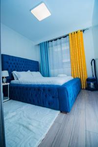 a blue bed in a room with a window at Beryl's Haven in Marimbeti