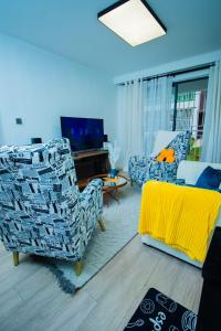 a living room with two chairs and a tv at Beryl's Haven in Marimbeti
