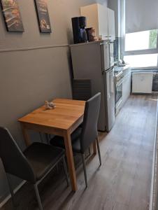 a kitchen with a wooden table and chairs and a refrigerator at FördeNest in Flensburg
