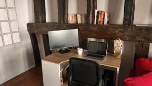 a desk with a laptop and a computer monitor at Appart proche gare centre ville bureau parking in La Loupe