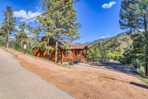 a log cabin in the mountains with a road at Fox Den Cozy Mountain Apt In GMF in Green Mountain Falls