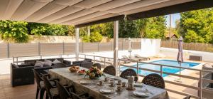 a table and chairs on a patio with a pool at Villa Montesol in La Drova